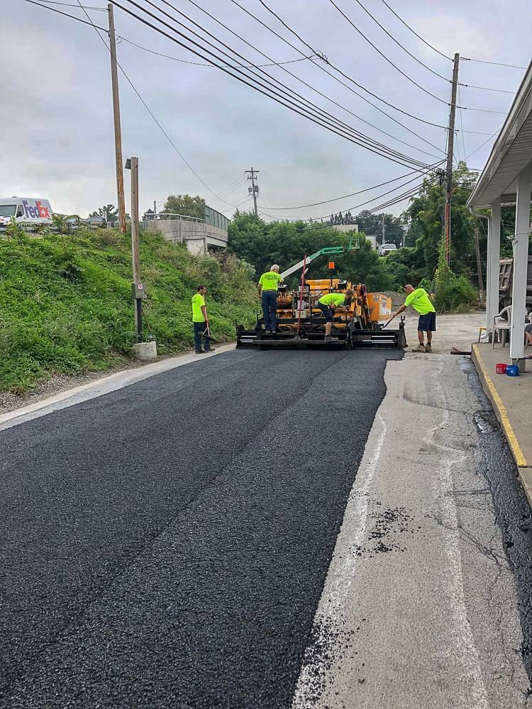 CMI Paving professionals pave an asphalt road as part of a commercial paving project