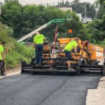 CMI paving professionals lay down asphalt on a roadwork job